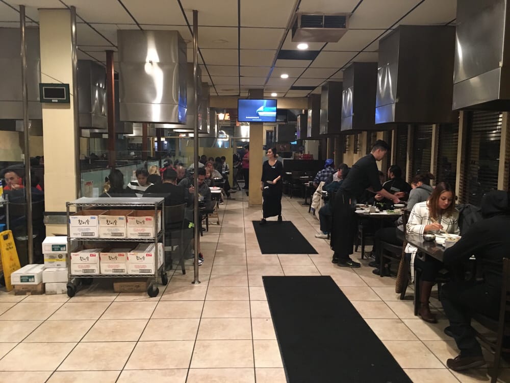 Long dining room lined with grill tables and vent hoods